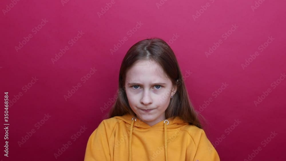 A young girl gets angry at the camera and clenches his fists.