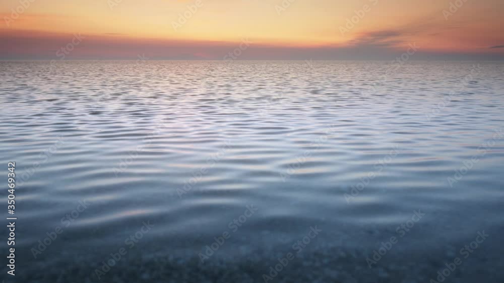 Sunset over the sea surface. Nature background. Calm and tranquil scene.