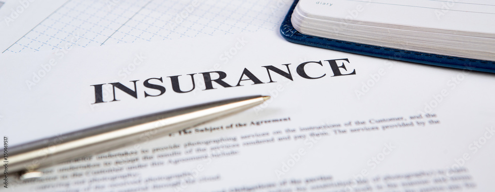 Closeup the silver ballpoint modern pen on insurance contract with planning in background. Closeup the silver ballpoint modern pen on insurance contract with planning in background.