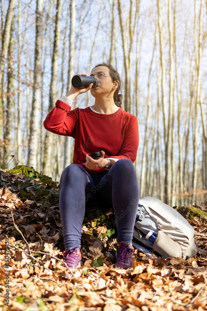 Spanish tourist girl sitting and drinking in the forest Spanish tourist girl sitting and drinking in the forest