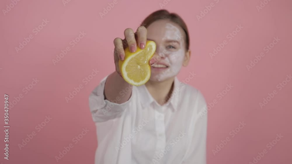 The concept of natural cosmetics. A girl with natural beauty and without makeup squeezes juice from a lemon. The concept of natural cosmetics. A girl with natural beauty and without makeup squeezes juice from a lemon.