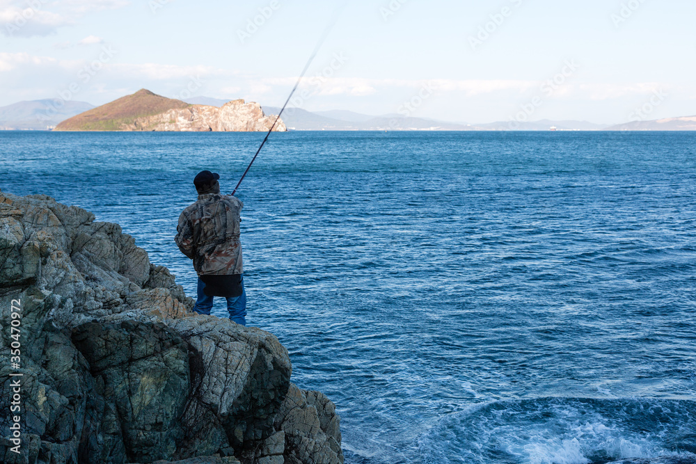 Fisherman catches fish on the sea Fisherman catches fish on the sea