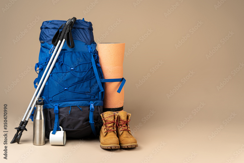 Blue backpack and hiking boots. Mountain gear ready for trip close up - obrazy, fototapety, plakaty 