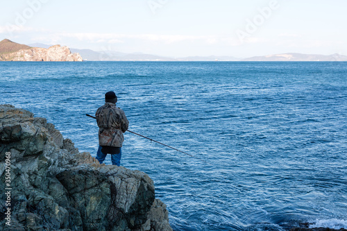 Fisherman catches fish from the rocks