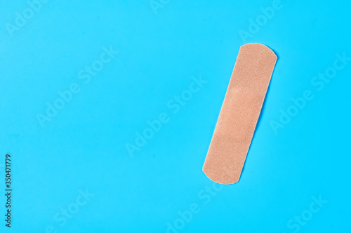 Sticky medical patch on blue background. Healthcare concept