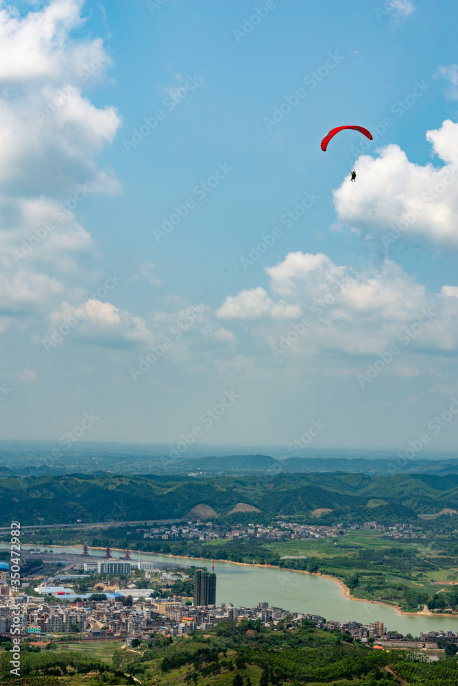 Outdoor city green hill scenery and paragliding Outdoor city green hill scenery and paragliding