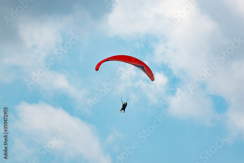 Manned paraglider flying in the blue sky
