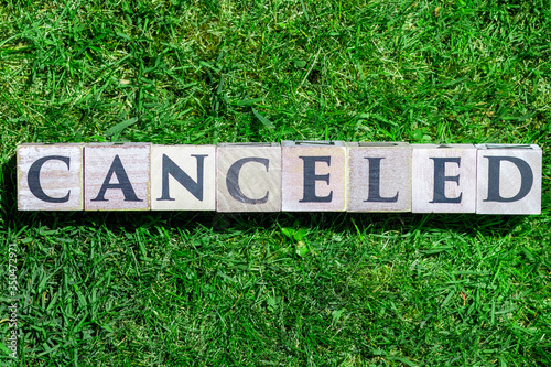 Canceled written on wooden blocks isolated on green grass background photo