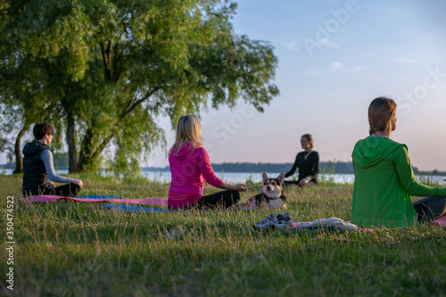 horizontal photo of group yoga class outdoors