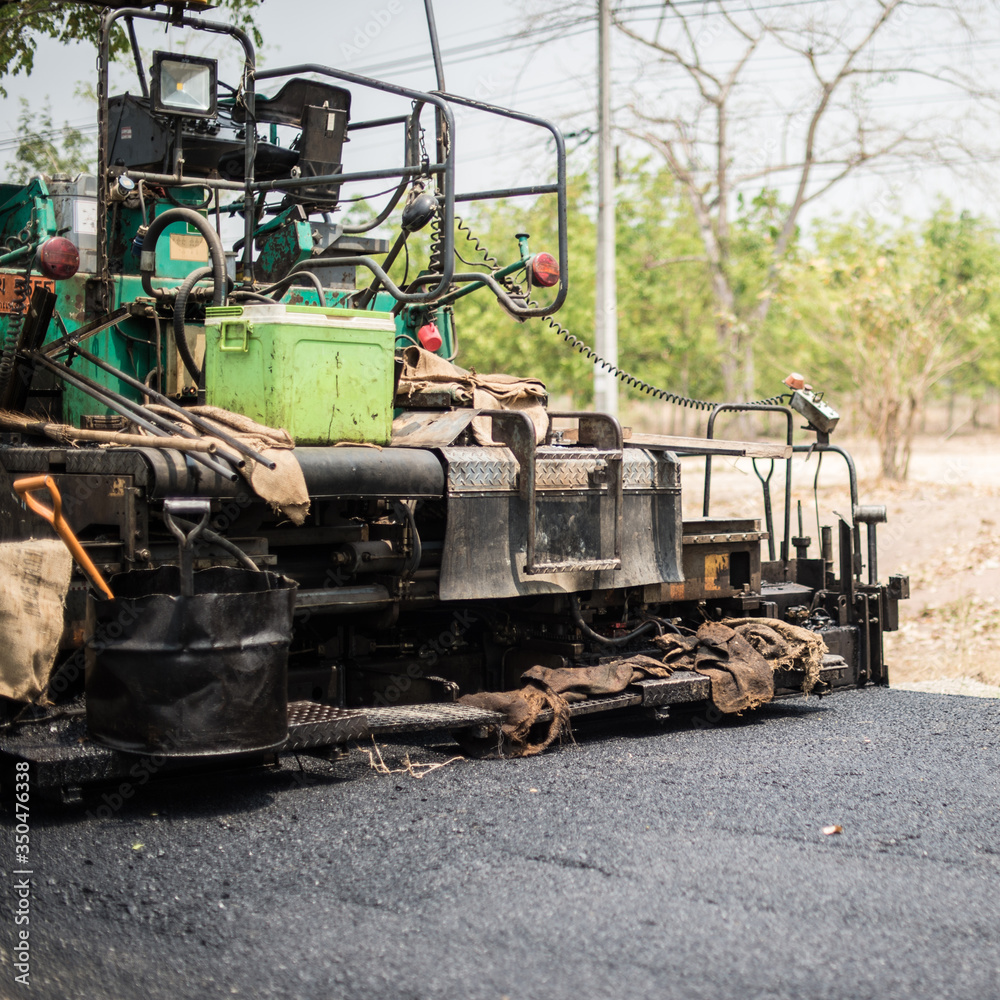 Closeup of grunge asphalt paving machines