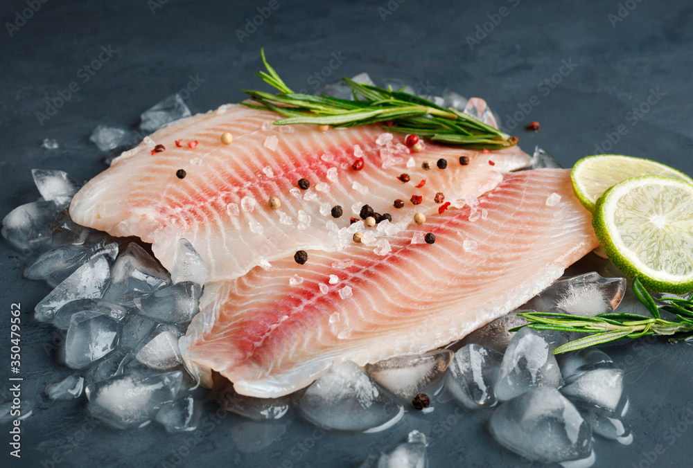 Fresh fish fillet of sea bass in ice on a dark slate background. Fresh fish fillet of sea bass in ice on a dark slate background.
