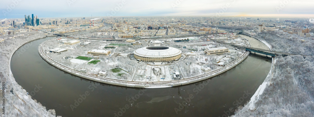 Aerial view of stadium and Moskva river. Moscow-city towers on the horizon. Beautiful spring sunrise over the city