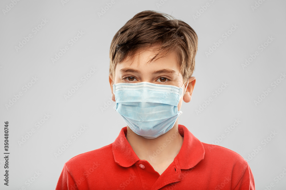 health protection, safety and pandemic concept - boy in protective medical mask over grey background health protection, safety and pandemic concept - boy in protective medical mask over grey background