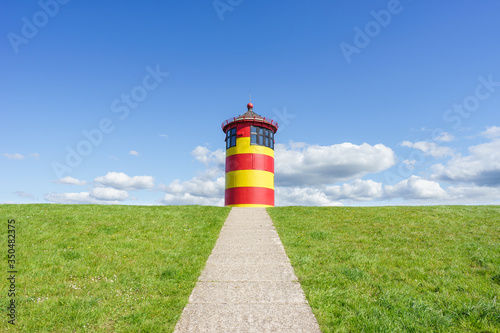 Bunt angemalter Leuchtturm bei Pilsum an der deutschen Nordseeküste