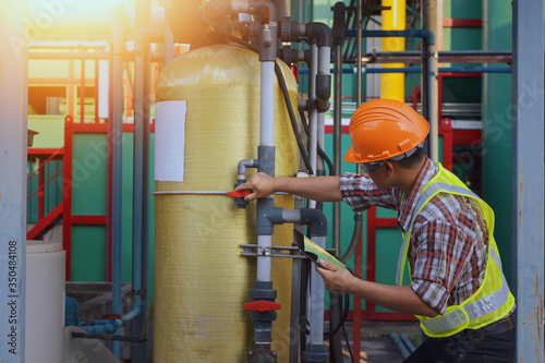 engineer discusses technical documentation with his help in the territory of a modern plant.Engineers working in the power plant area