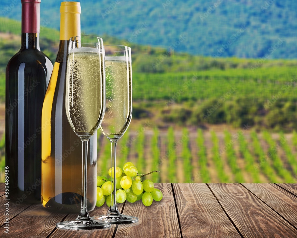 Obraz premium Quality delicious champagne wine, grapes and two wine glasses on the desk