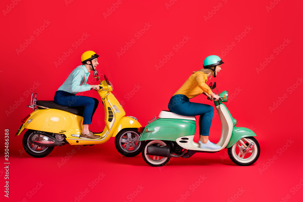 Profile side view of her she his he nice attractive crazy overjoyed cheerful cheery couple riding moped enjoying weekend free time isolated on bright vivid shine vibrant red color background