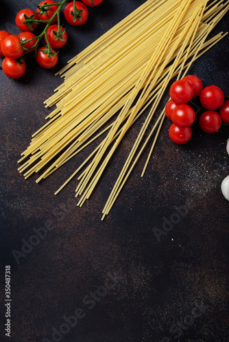 spaghetti, tomato and garlic on the black table