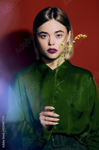 Closeup fashion portrait of beautiful young white girl with flowers and a healthy clean skin. 