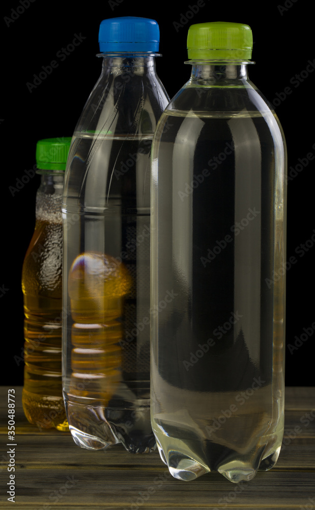 Water bottles and juice isolated on a black background. Water bottles and juice isolated on a black background.