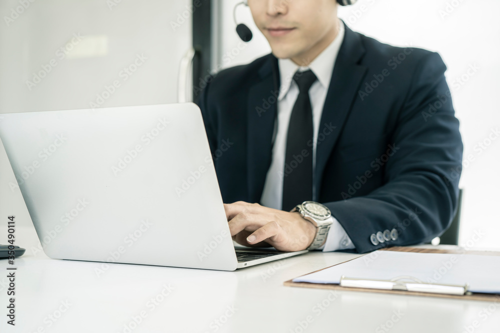 Businessman using headset phone in a call centre. Team of business people working for communication and consulting people at customer service office. Businessman using headset phone in a call centre. Team of business people working for communication and consulting people at customer service office.