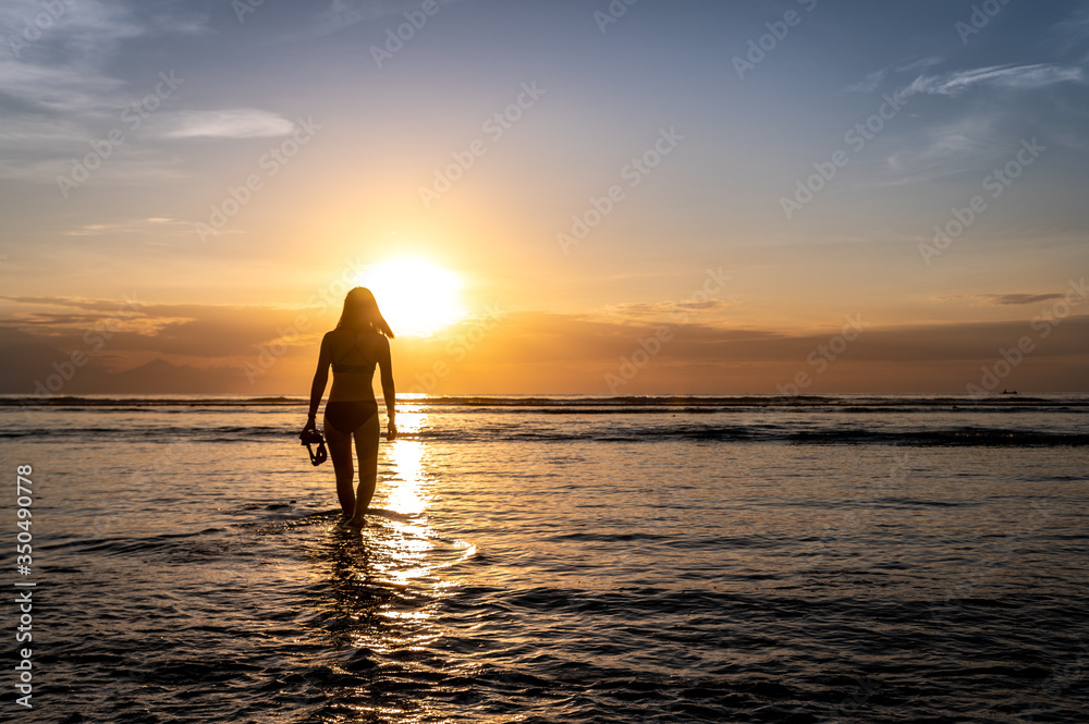 diver girl on the beach at sunset