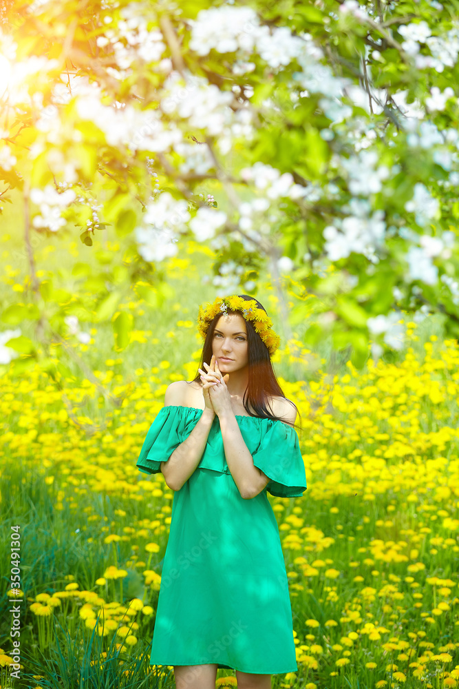 beautiful girl enjoys spring with a wreath of dandelions on her head beautiful girl enjoys spring with a wreath of dandelions on her head