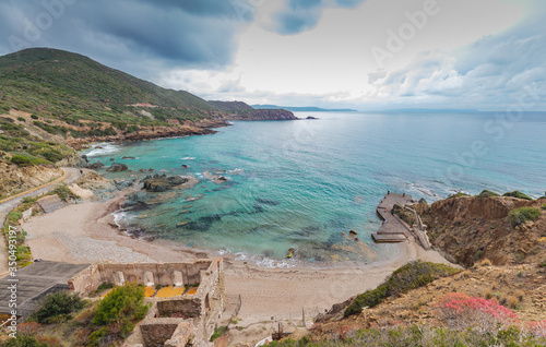 Fototapeta Naklejka Na Ścianę i Meble -  Masua beach with walls of old mining buildings.South Sardinia