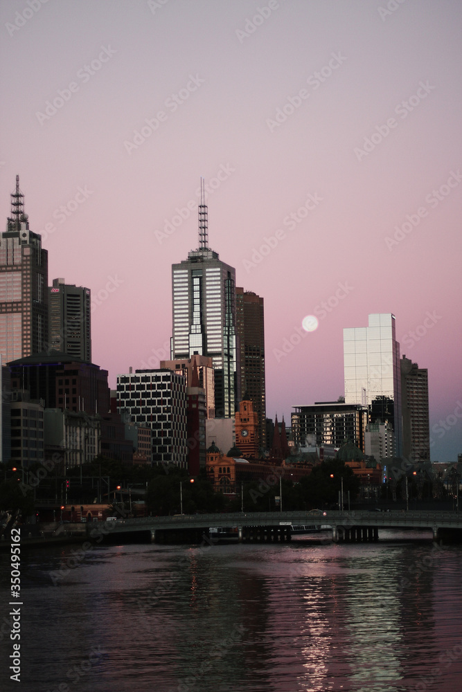 Fototapeta premium Purple sky sunset with a river and city building view