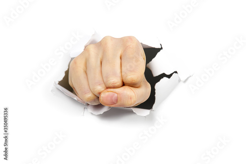 punching hole through paper wall with fist. Punch break through the paper wall. Fist coming out the paper hole isolated on white background