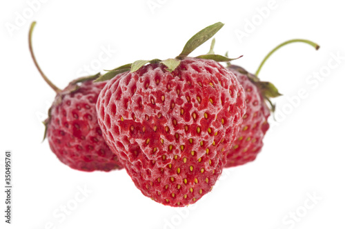 Frozen red strawberries isolated on a white background close-up.