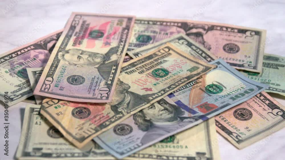 American money falling onto a marble countertop. American money falling onto a marble countertop.