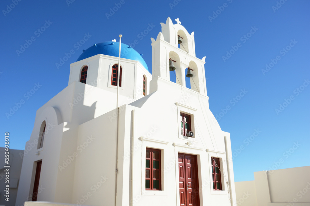 Blue dome chapel with bell tower in Oia, Santorini, Greece. View of traditional white and blue building, Greek orthodox church on Santorini Island