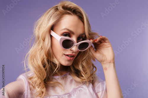 Image of happy caucasian woman in sunglasses looking at camera