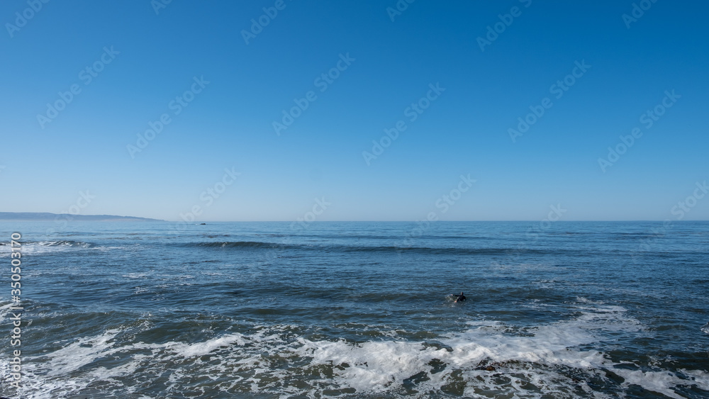 Surfer in the waves at Pacific ocean