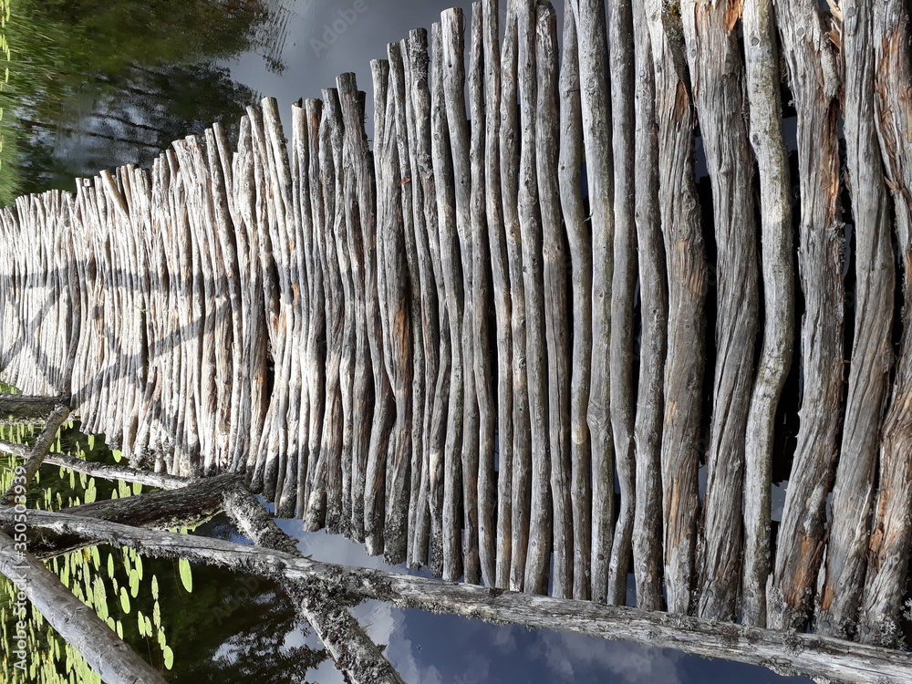 Old bridge made of round, gray branches Old bridge made of round, gray branches