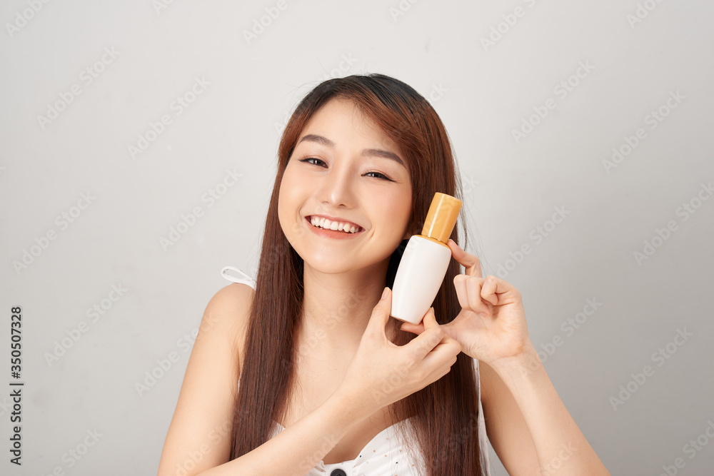 Asian woman model present showing cosmetic make up package products empty copy space on her hand palm Asian woman model present showing cosmetic make up package products empty copy space on her hand palm