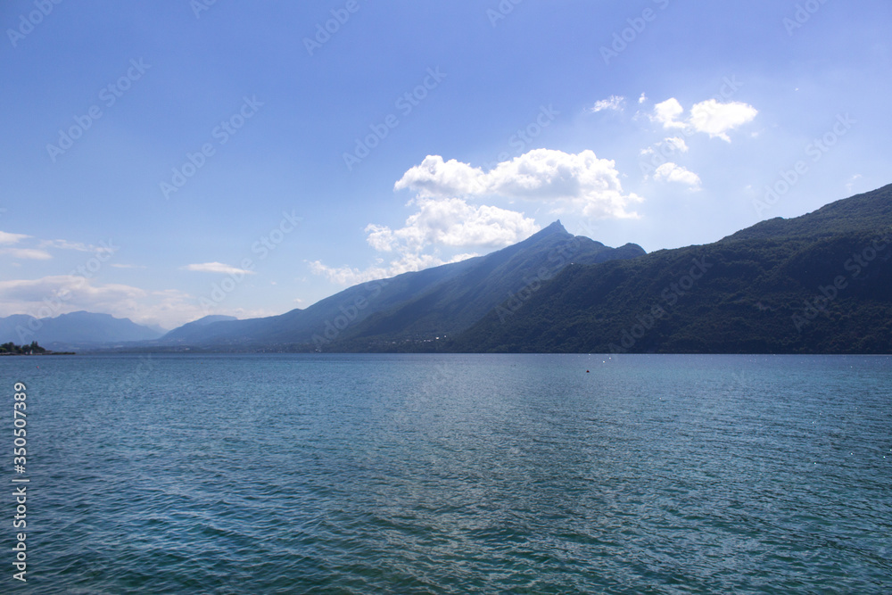 Beautiful panoramic lake shore with alps mountain range view summer water sports  hiking camping concept