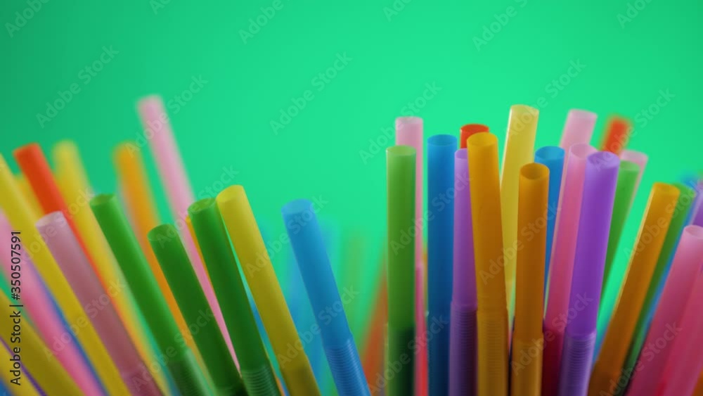 Plastic colored cocktail beverage tubes rotate on a green background. Plastic colored cocktail beverage tubes rotate on a green background.