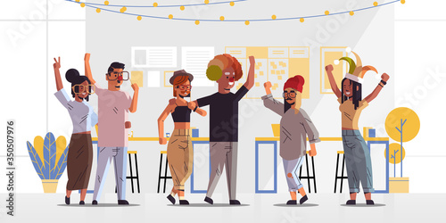 first april fool day mix race coworkers in funny jester hats holiday celebration office interior horizontal full length