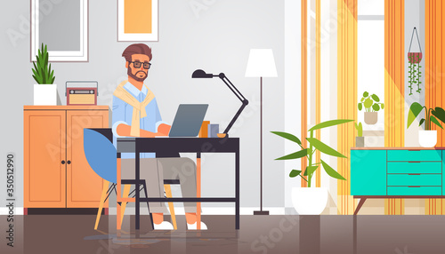 freelancer using laptop man sitting at workplace self-isolation coronavirus pandemic quarantine concept modern cabinet interior full length horizontal vector illustration