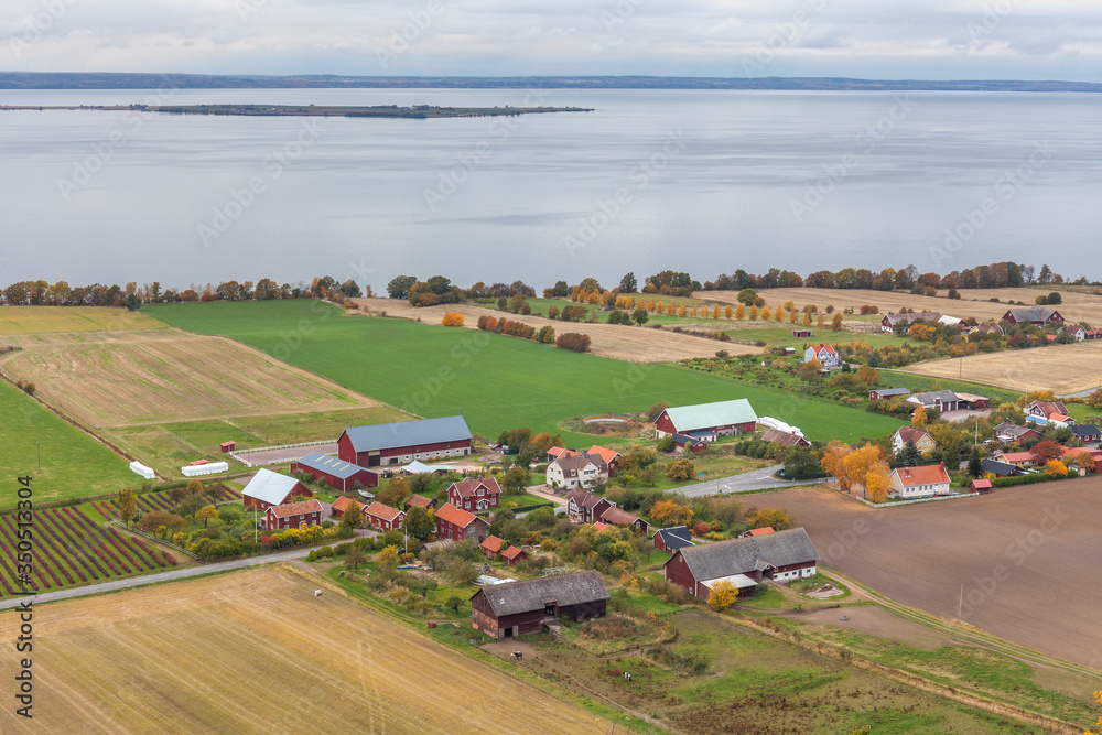 Obraz premium View of Lake Vattern with a picturesque little Swedish village on the coast photographed from the fortress Brahehus in Granna, Jonkoping, Sweden.
