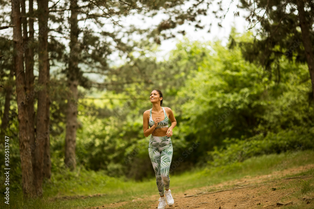 Young fitness woman running at forest trail Young fitness woman running at forest trail