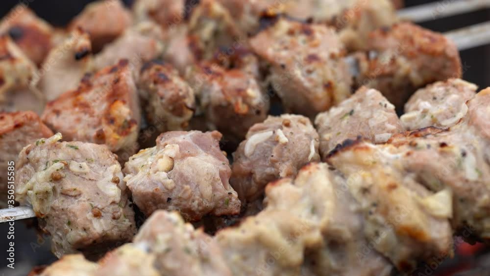 Barbecue meat on skewers, beautifully browned meat on the grill. A pork meat on the grill in the spring garden. Cooking shashlik on the mangal in nature. Shashlik cooking on the coals