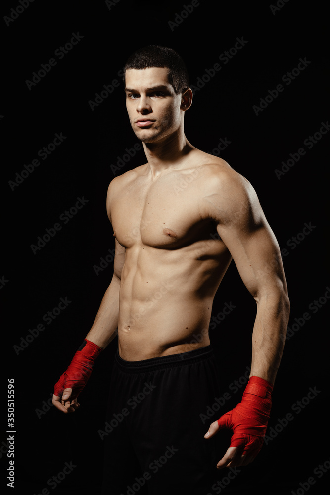 Portrait of male boxer posing in boxing stance against black background. Portrait of male boxer posing in boxing stance against black background.