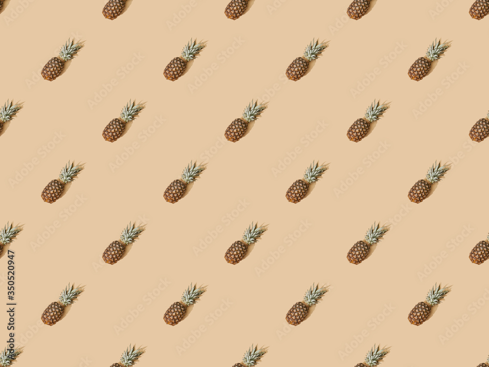 top view of whole ripe pineapples on beige background, seamless pattern