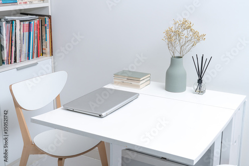 Working at home in a minimalist home. Dining tables and chairs and furnishings in a minimalist modern home.  photo