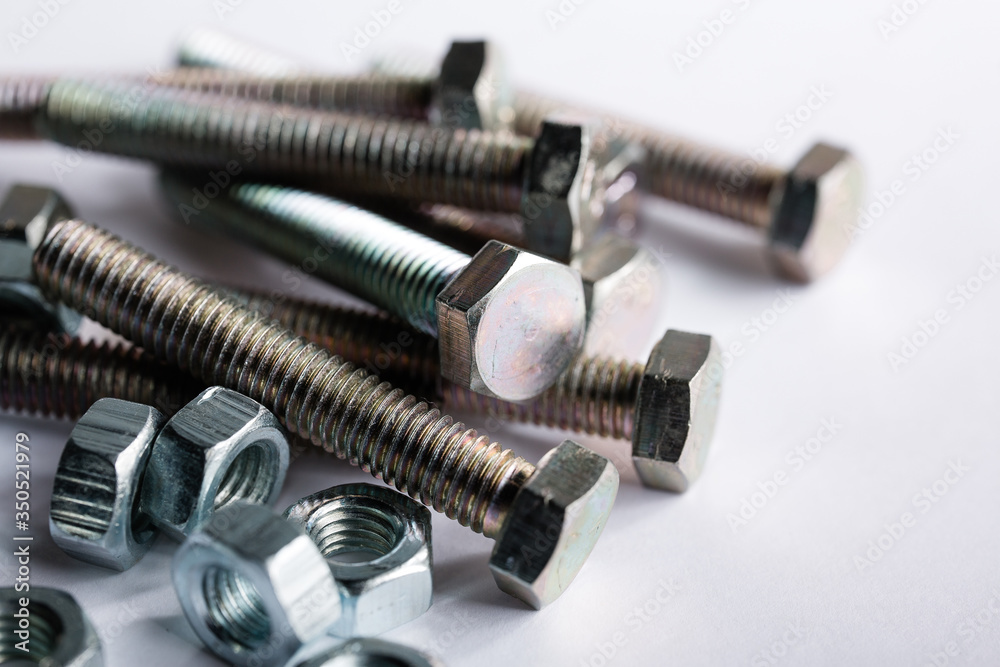 macro shot. Bolts and nuts lie on a white background. Close-up of parts for construction and repair macro shot. Bolts and nuts lie on a white background. Close-up of parts for construction and repair