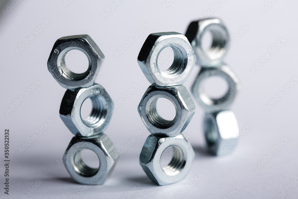 macro shot Metal nuts laid out in the shape of a figure. Imitation of honeycombs. Repair Concepts macro shot Metal nuts laid out in the shape of a figure. Imitation of honeycombs. Repair Concepts