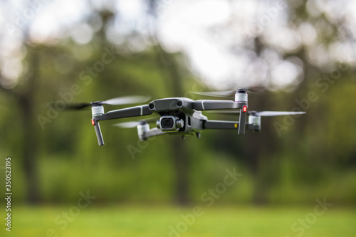 Quadcopter flying on a clear sunny green day background